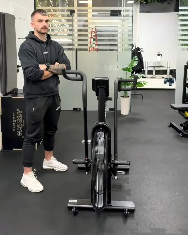 Kuba Matlak w sali treningowej przy rowerku